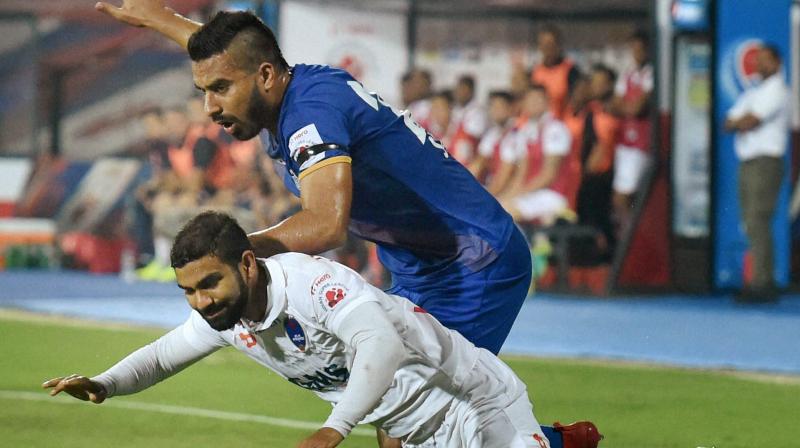 Players of Mumbai City FC (blue jersey) and Delhi Dynamos FC (white jersey) clash during their ISL match in Mumbai on Saturday (Photo: AP)