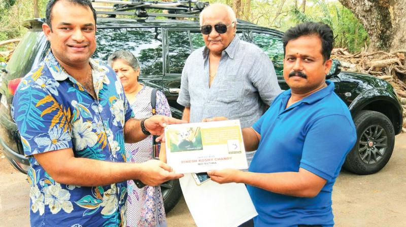 Rinesh Koshy Chandy hands over the name board of Sugar Gliders to T. V. Anil Kumar, superintendent, Thiruvananthapuram Zoo.