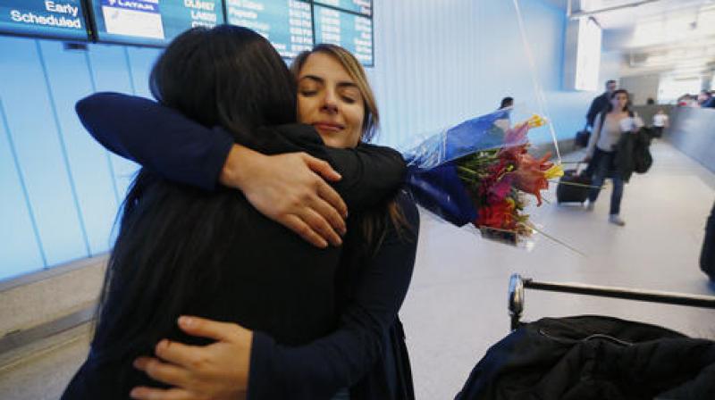 California student Sara Yarjani, right, is welcomed by her sister Sahar Muranovic after arriving at the Tom Bradley International Terminal at Los Angeles International Airport. (Photo: AP)