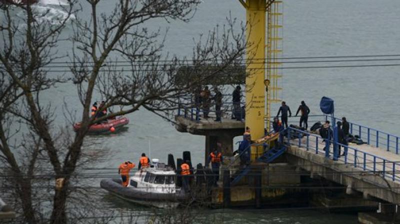Russian rescue workers collect wreckage from the crashed plane at a pier just outside Sochi, Russia. (Photo: AP)