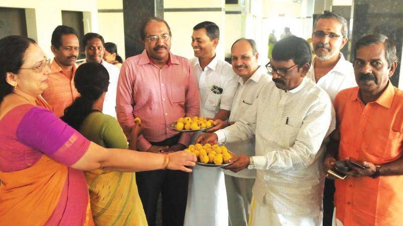 Justice V R Krishna Iyer Movement volunteers distribute sweets on the occasion of the Kochi Cancer Centre OP opening on Tuesday. (Photo: DC)