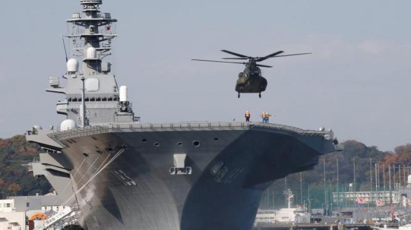 A helicopter lands on the Izumo, Japan Maritime Self Defense Forces (JMSDF) helicopter carrier, at JMSDF Yokosuka base in Yokosuka, south of Tokyo (Photo: Reuters)