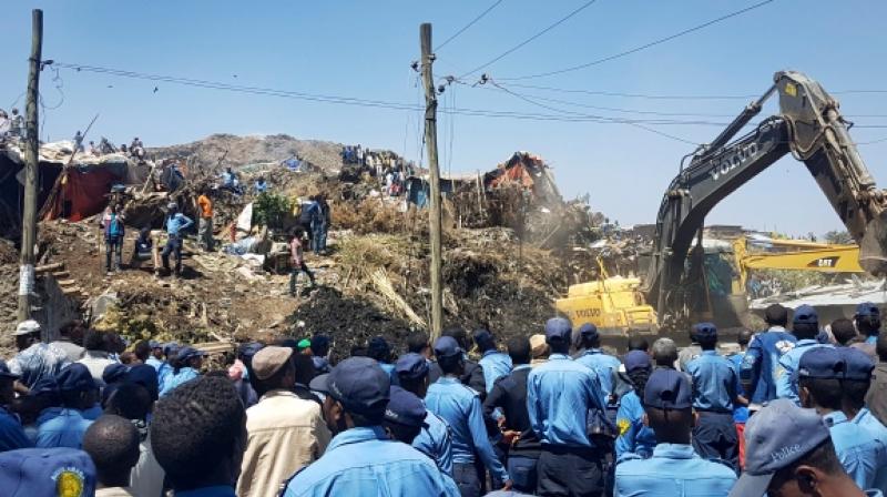Police officers are seen at the scene of a garbage landslide