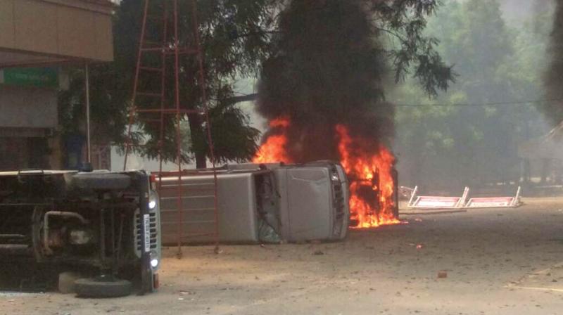 Police vehicles on fire at Thoothukudi on Tuesday.