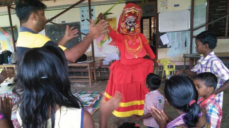 A class being given to students of Govt U.P School, Moozhiyar in Pathanamthitta making use of a Theyyam artiste.