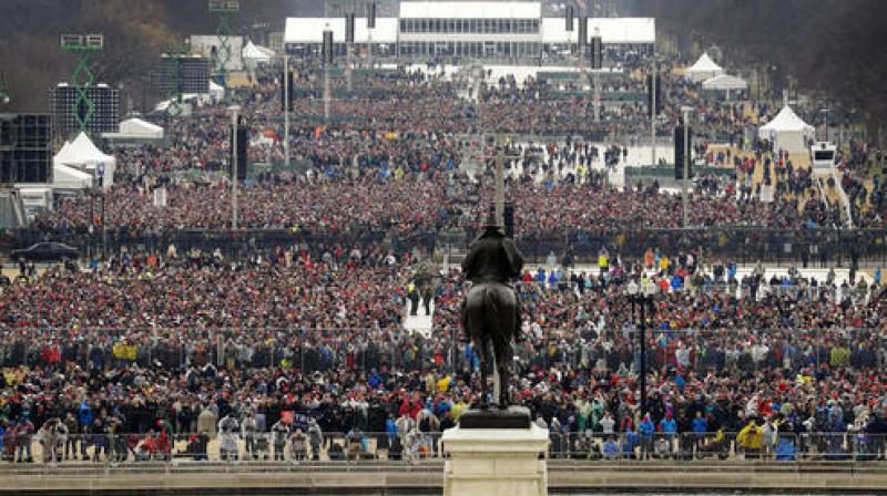 People stand on the National Mall to listen to the 58th Presidential Inauguration for President Donald Trump at the U.S. Capitol in Washington. (Photo: AP)