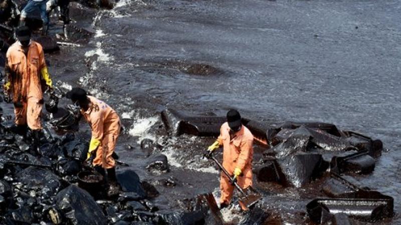 Firefighters and volunteers try to clean up oil that has washed ashore, in Chennai (Photo: PTI)