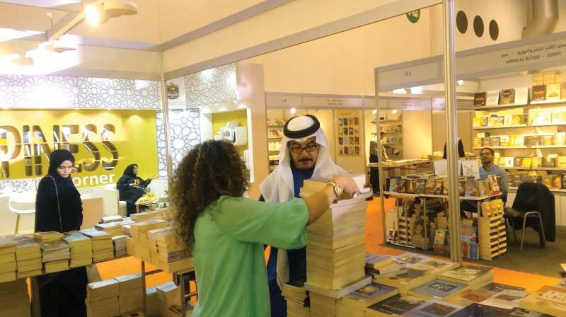 Nasser al-Dhaheri selects books for the Arabic department at Sharjah International Book Fair.