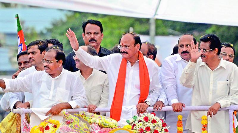 Union minister M. Venkaiah Naidu and other leaders greet the crowd during a rally held in Kakinada on Friday. BJP state president K. Haribabu and Kakinada MP T. Narasimham are also seen. (Photo: DC)