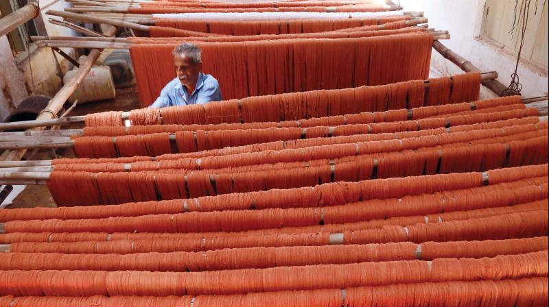 A weaver drying the washed yarns that were drenched in floods,( Photo-Arun Chandrabose)