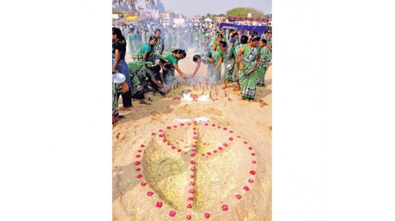 Relatives and family members pay tributes to the victims of tsunami at Marina beach near Pattinapakkam on Wednesday.	DC