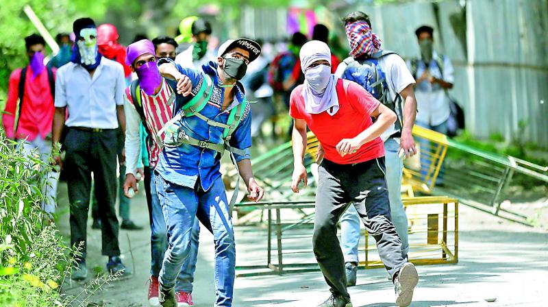 Kashmiri students throw stones on policemen as they clash in Srinagar in Kashmir on Monday. (Photo: AP)