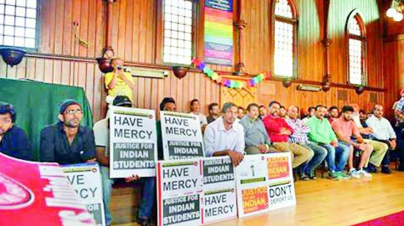 Students taking refuge in a church hold placards seeking mercy and support.