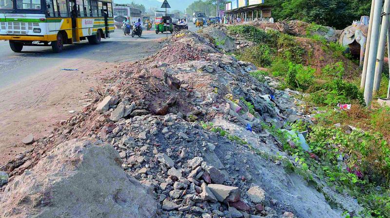 Construction debris dumped at canal bunds on national highway near Krishnalanka in Vijayawada. 	 DC