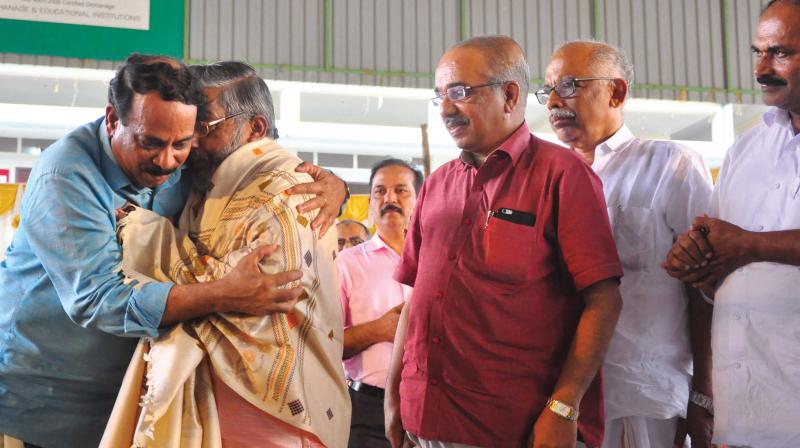 District Panchayat president hugs P.J. Joseph during the gathering on Saturday.