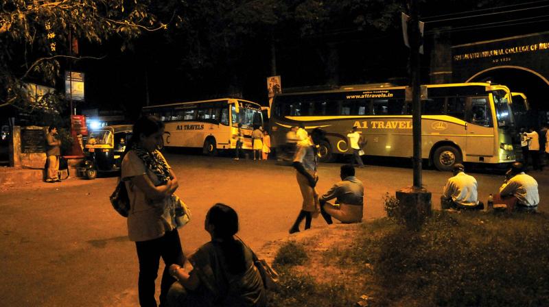 Passengers wait for inter-state private buses in front of Swathi Thirunal College of Music. 	(Photo: DC file)