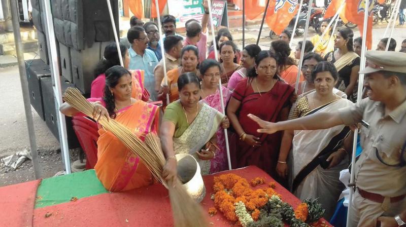 Mahila Morcha workers sprinkle water mixed with cow dung at MPs venue of protest.