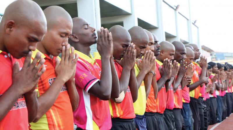 Athletes from St Georges HS, Kothamangalam, pray before their practice session on the eve of the 61 State Athletics meet in Pala on Thursday. 	(Photo: Rajeev Prasad)