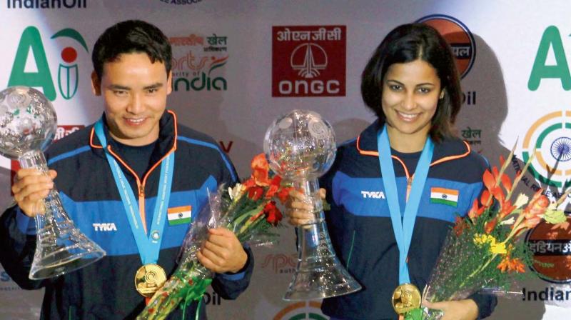 Jitu Rai and Heena Sidhu pose with their gold medals and trophies in the 10m air pistol mixed team event of the ISSF World Cup Final at the Karni Singh ranges in New Delhi on Tuesday.