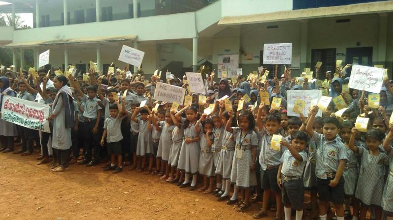 Children at Crescent Public School, Mavoor, show the cards after being administered MR vaccine.