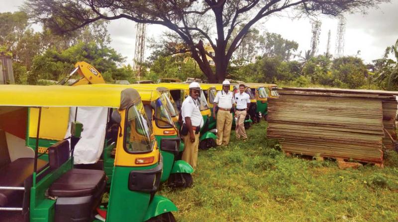Traffic policemen with the autorickshaws seized  during a special drive in Bengaluru on Monday  (Photo:DC)