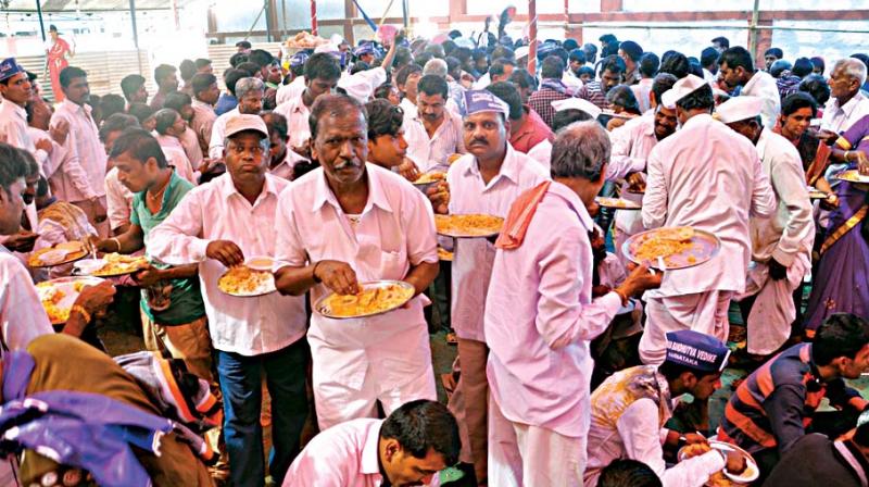People having meals during Mahaparinirvan Divas celebration at  a graveyard in Belagavi on Tuesday. Inset is ex-minister Jarkiholi
