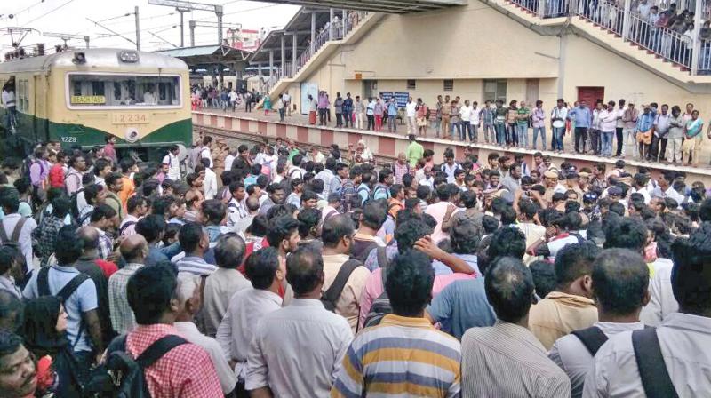 Commuters block a local train in Tambaram railway station condemning the cancellation of fast locals, on Saturday. (Photo: DC)