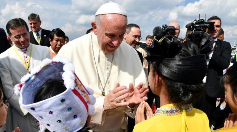 Catholics in colourful ethnic traditional dress waved flags and danced at Yangons airport in a joyful welcome for the pope, making the first visit to the country by a pontiff. (Photo: AFP)