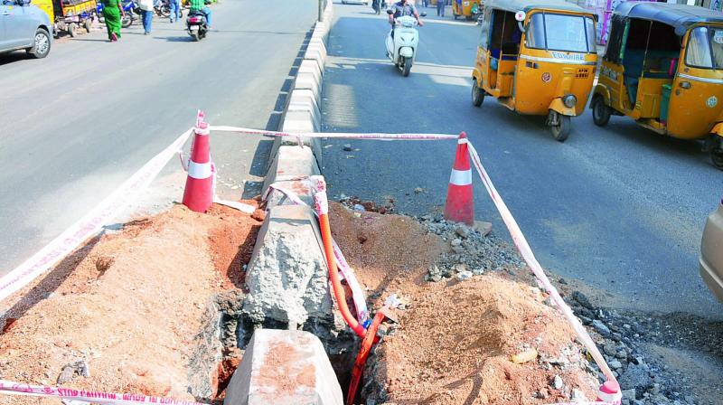 L&T personnel dig up the median on the Malkajgiri-Neredmet road to install CCTV cameras as part of a traffic police project. The road was laid recently.