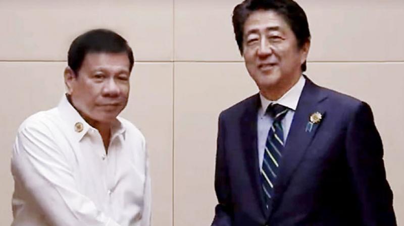 Japanese PM Shinzo Abe, left, and Philippines Rodrigo Duterte in Manila.