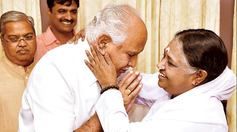 State BJP president B.S. Yeddyurappa with Mata Amritanandamayi at her Ullal ashram in Bengaluru on Thursday. (Photo: KPN)