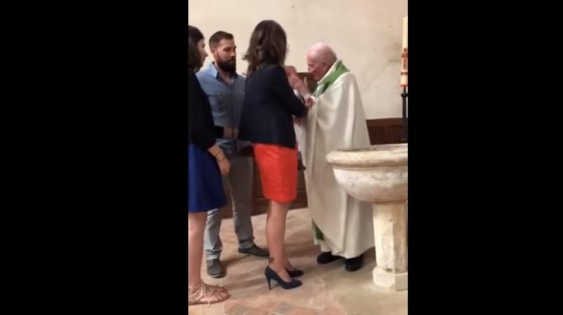 The man who appears to be the childs father prised the child out of the priests grip, even as the cleric struggled for possession of the child. (Youtube Screengrab/ hydroxy maztaz)