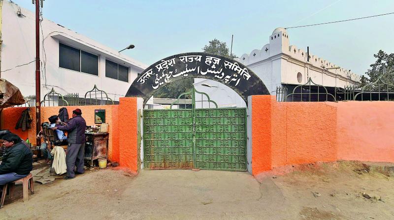 The BJP government paint the outer wall of the UP State Haj Committee office in saffron, at Lucknow on Friday. (Photo: PTI)