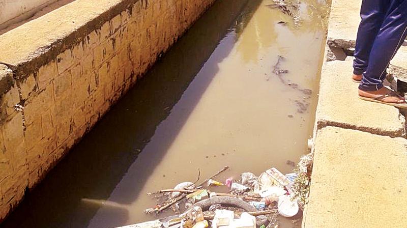 The families used wooden planks to cross the drain, which is filled with sewage.