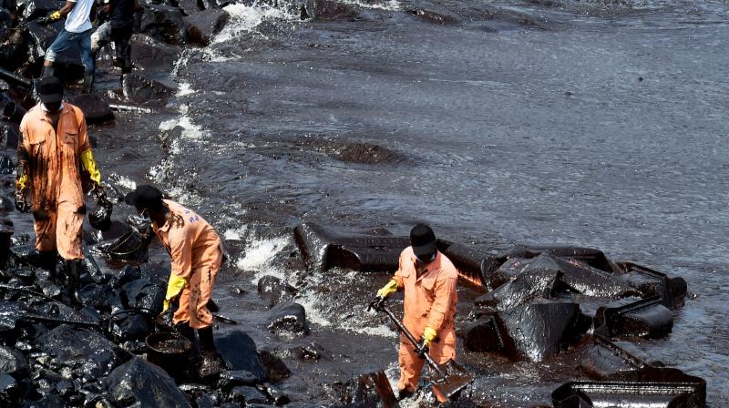 Firefighters and volunteers try to clean up oil that has washed ashore, in Chennai. (Phoot: PTI)