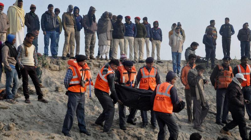 NDRF personnel recovering a body of a passenger from a boat which capsized in river Ganga, in Patna. (Photo: PTI)