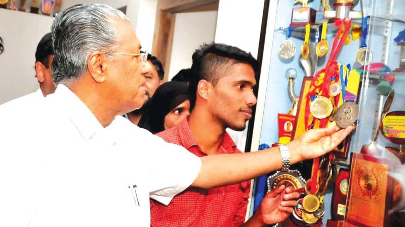 Muhammed Ajmal shows his medals to Chief Minister Pinarayi Vijayan when he visited his house. (Photo: DC)
