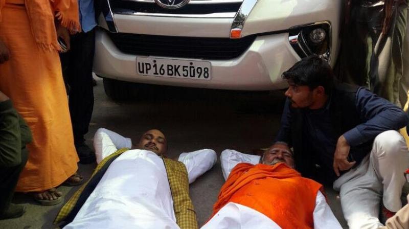 Bharatiya Janata party leaders Sunder Lal Dixit and Rambabu Dwivedi as mark of protest on Thursday lay down in front of the car of the partys state chief Keshav Prasad Maurya. (Photo: ANI Twitter)