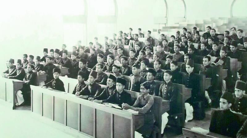 A rare photograph of students wearing the Deccani sherwania long coat in dark-colours along with a cap attending classes at Osmania University. This dress code was prevalent from 1918 well into the 1950s. Women students wore salwar kameez and married women attending the university wore saris always covering their heads in keeping with the traditions.