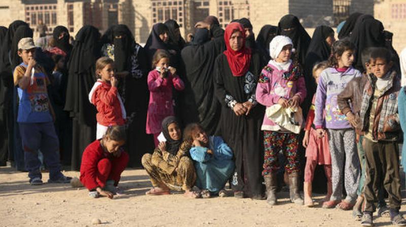 Civilians wait for humanitarian aid to be distributed outside Mosul, Iraq. (Photo: AP)