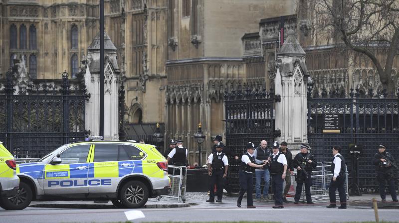 Police on the scene after sounds similar to gunfire have been heard close to the Houses of Parliament, London. (Photo: AP)