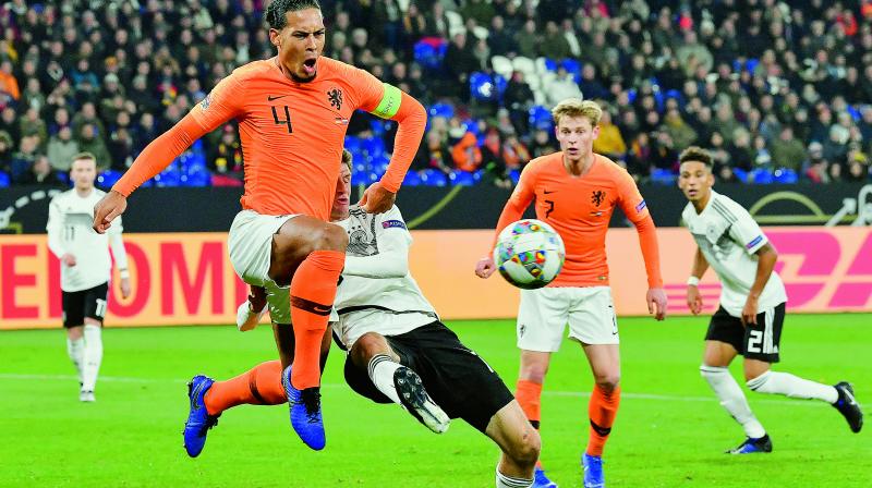 Virgil Van Dijk (left) of Netherlands and Germanys Thomas Mueller compete for the ball during their UEFA Nations League match in Gelsenkirchen, Germany, on Monday. The match ended 2-2.	(Photo: AP)