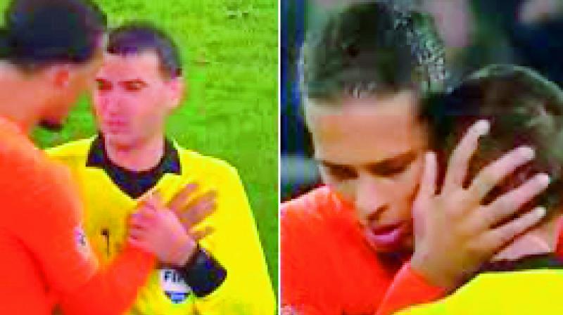 Dutch captain Virgil Van Dijk (in orange) consoles referee Ovidiu Hategan who recently lost his mother.