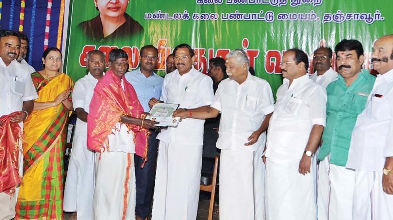 Mafoi.K.Pandiarajan, minister for culture and Tamil official language distributes  awards to a traditional musician at Thanjavur on Tuesday (Photo: DC)