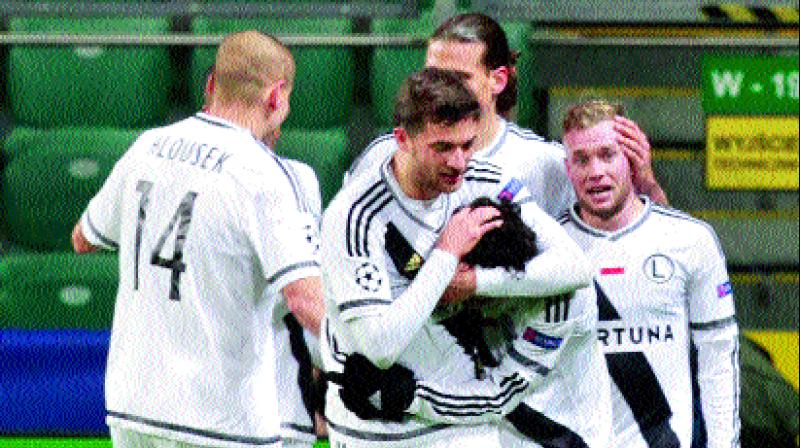 Legia Warsaw players celebrate in their Group F home match against Real Madrid at Stadion Wojska Polskiego on Wednesday.	(Photo:  AP)