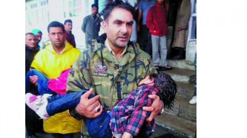 A policeman carries an injured child to a hospital after the cable-car snapped in Gulmarg in north Kashmirs Baramulla district. (Photo: PTI)