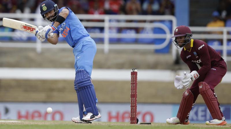 Indias captain Virat Kohli plays a shot under the watch of West Indies Shai Hope during their second ODI cricket match at Queens Park Oval in Port of Spain. (Photo: AP)