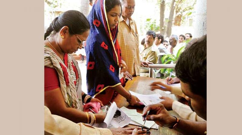 Officials apply indelible ink on customers at State Bank of Mysore, in  Bengaluru on Wednesday.