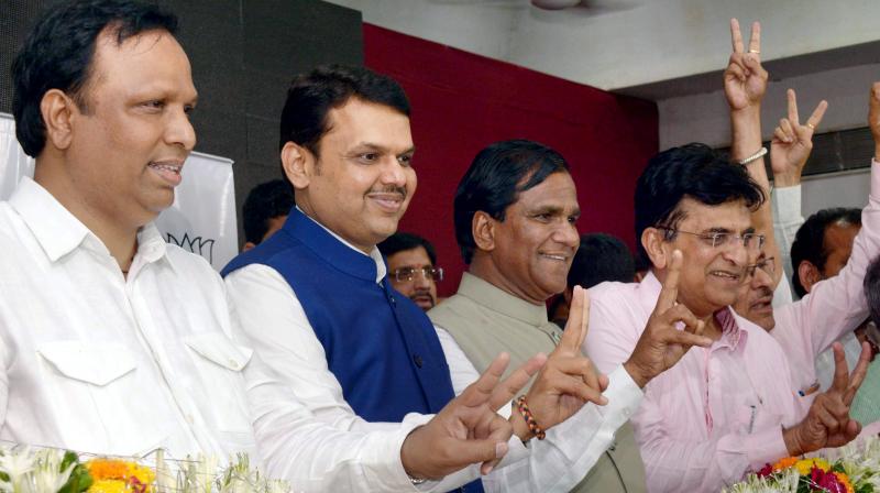 Chief Minister of Maharashtra Devendra Fadanvis and party state president Ravsaheb Danve along with Kirit Somaiya flash victory signs after the BMC poll results at Mumbai BJP office. (Photo: PTI)