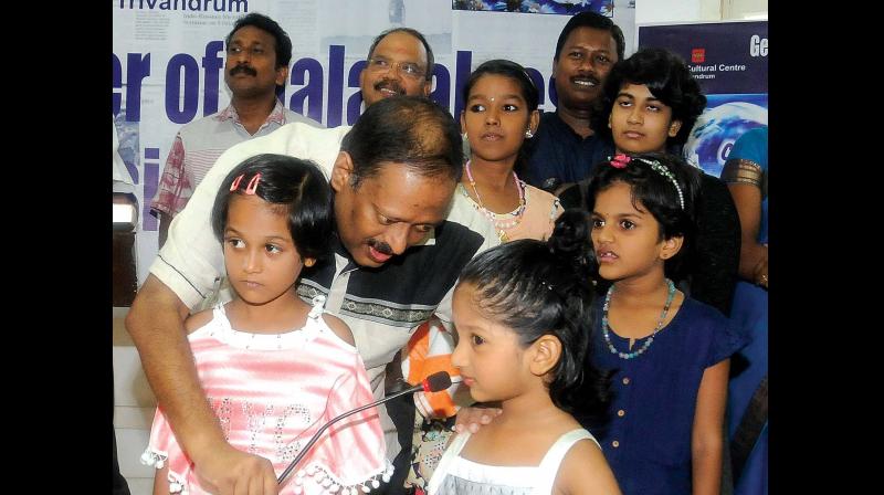 Tanya, a little girl at the get together of Keralites with Russian names, speaks in Russian as Ratheesh C Nair, Honorary Consul of the Russian Consulate, holds the microphone for her.   (Photo: A.V. MUZAFAR)